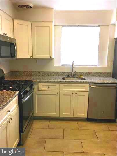 5319 Pooks Hill Road, Unit 1 Bethesda, MD 20814 - Photo 35 of 37 a kitchen with granite countertop a sink a stove and cabinets