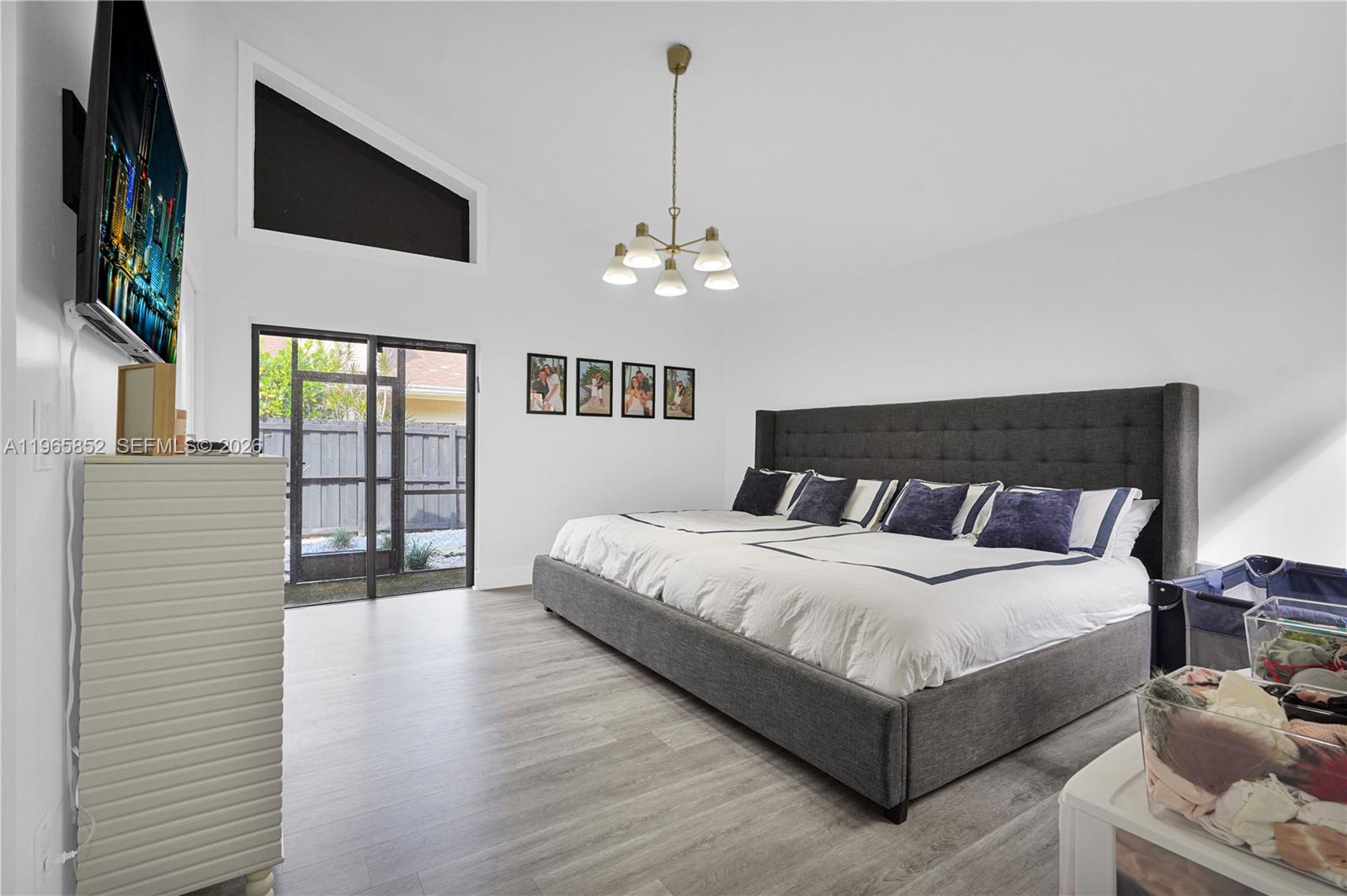 7635 Sierra Terrace West Boca Raton, FL 33433 - Photo 22 of 53 a spacious bedroom with a bed and a chandelier