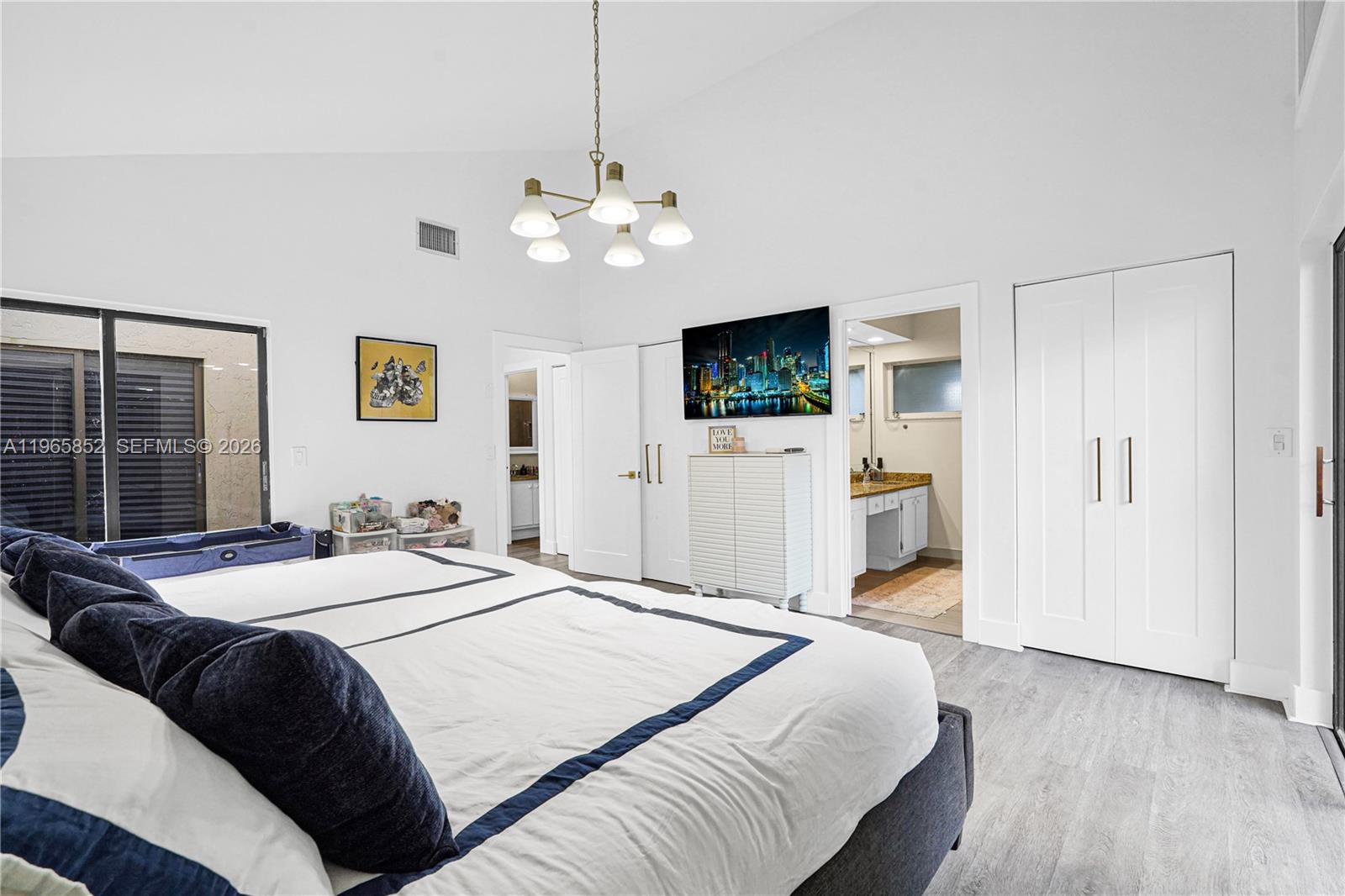 7635 Sierra Terrace West Boca Raton, FL 33433 - Photo 24 of 53 a spacious bedroom with a bed and a flat screen tv