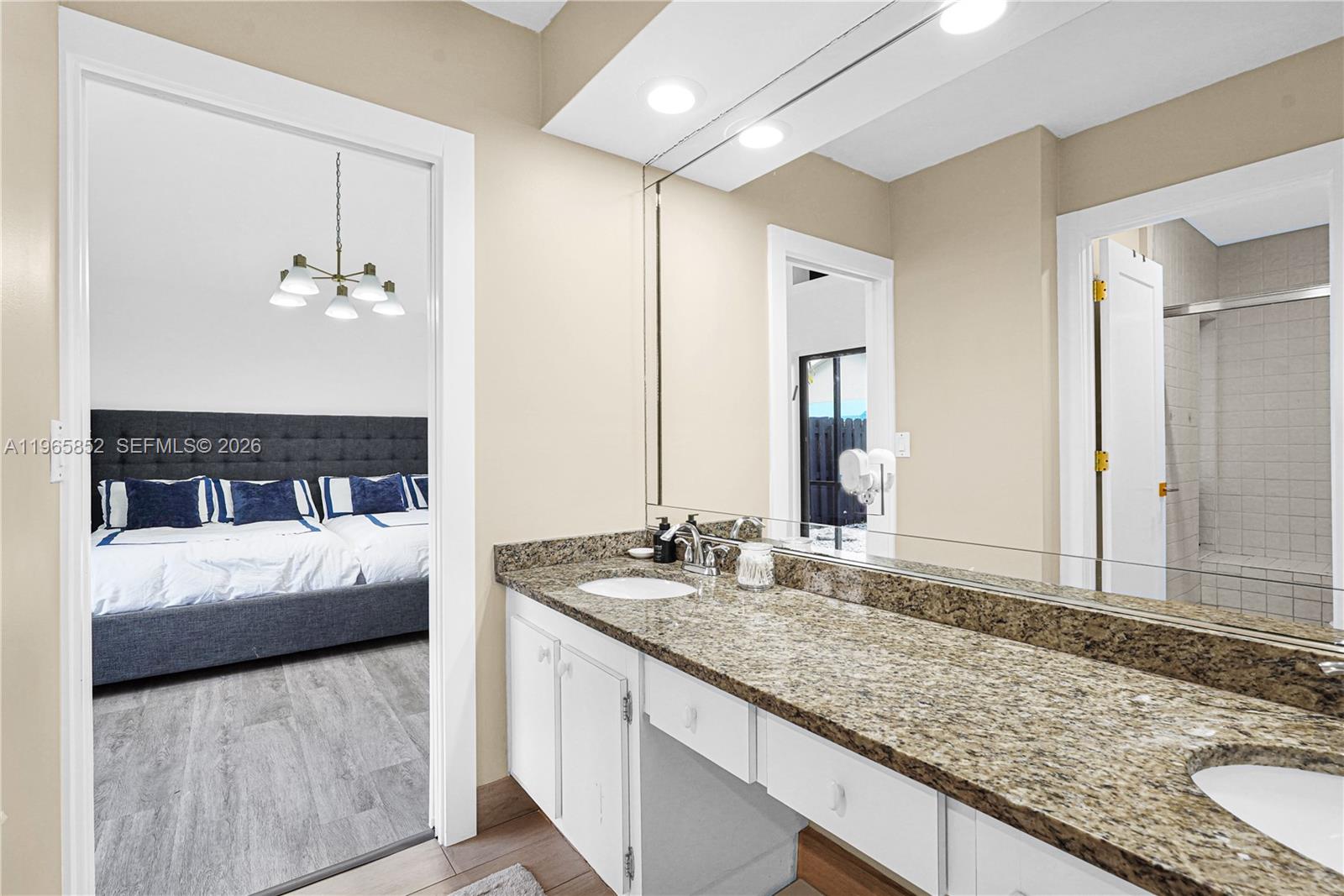 7635 Sierra Terrace West Boca Raton, FL 33433 - Photo 38 of 53 a en suite bathroom with a granite countertop sink and a mirror