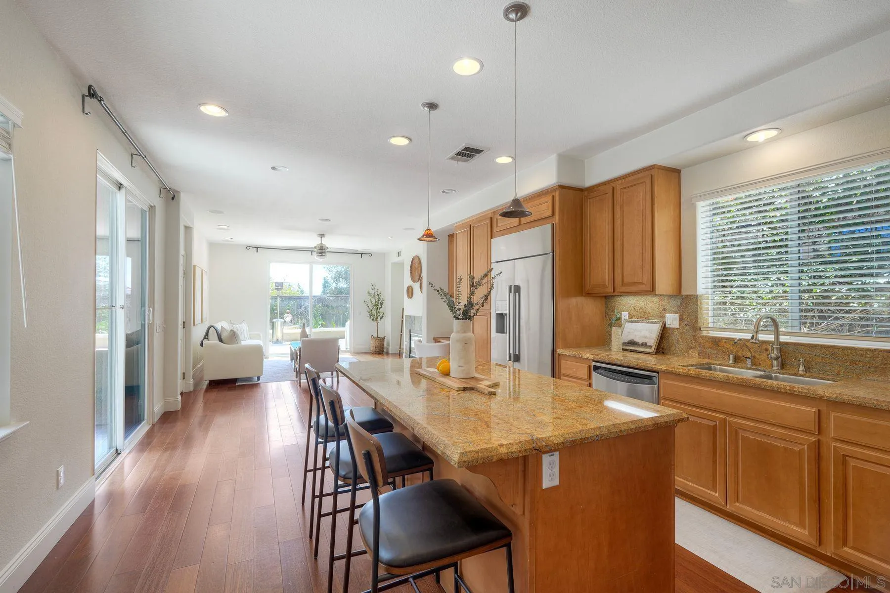 1614 Reflection Street San Marcos, CA 92078 - Photo 13 of 40 a kitchen with stainless steel appliances granite countertop a sink a stove a refrigerator cabinets and dining table