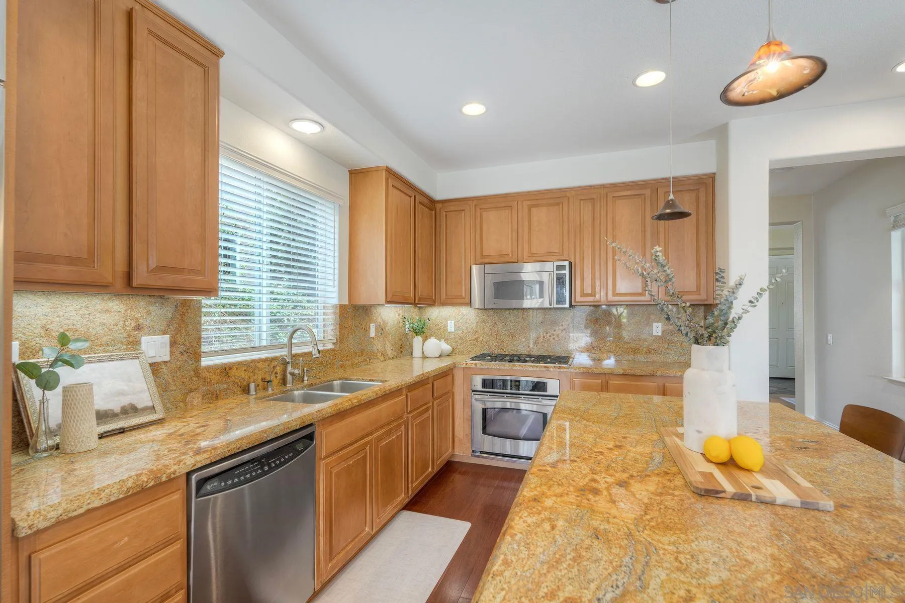 1614 Reflection Street San Marcos, CA 92078 - Photo 18 of 40 a kitchen with stainless steel appliances granite countertop a sink stove and cabinets