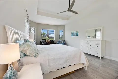 a bedroom with a bed and a chandelier fan