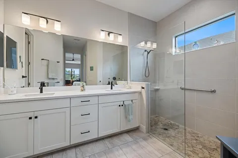 a bathroom with a sink a toilet a mirror a vanity and shower
