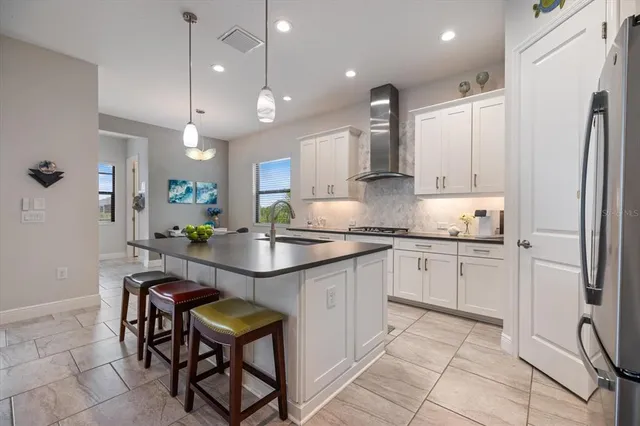a kitchen with stainless steel appliances granite countertop a kitchen island and a refrigerator