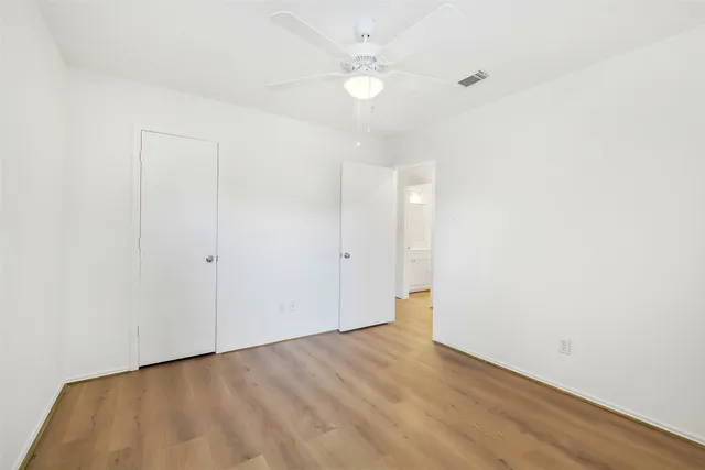 a view of an empty room with wooden floor