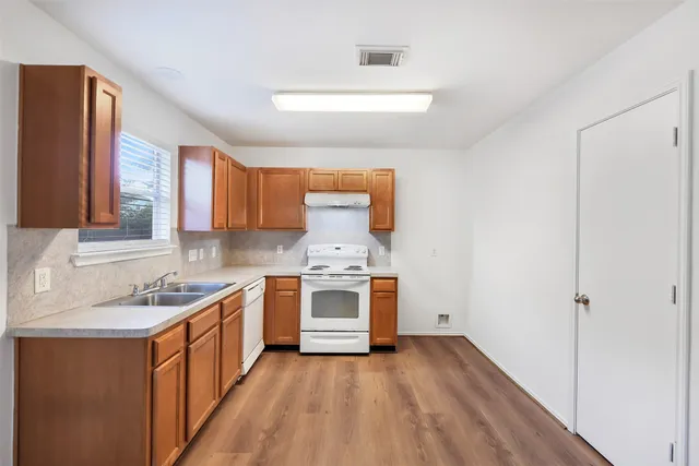 a kitchen with a sink stove and cabinets