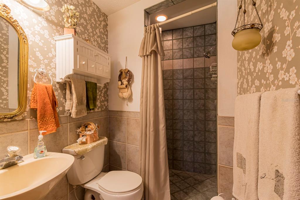 9215 Ridge Road New Port Richey, FL 34654 - Photo 23 of 71 a bathroom with a toilet and shower