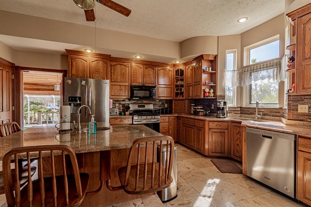 9215 Ridge Road New Port Richey, FL 34654 - Photo 29 of 71 a kitchen with stainless steel appliances granite countertop a stove top oven a sink and dishwasher