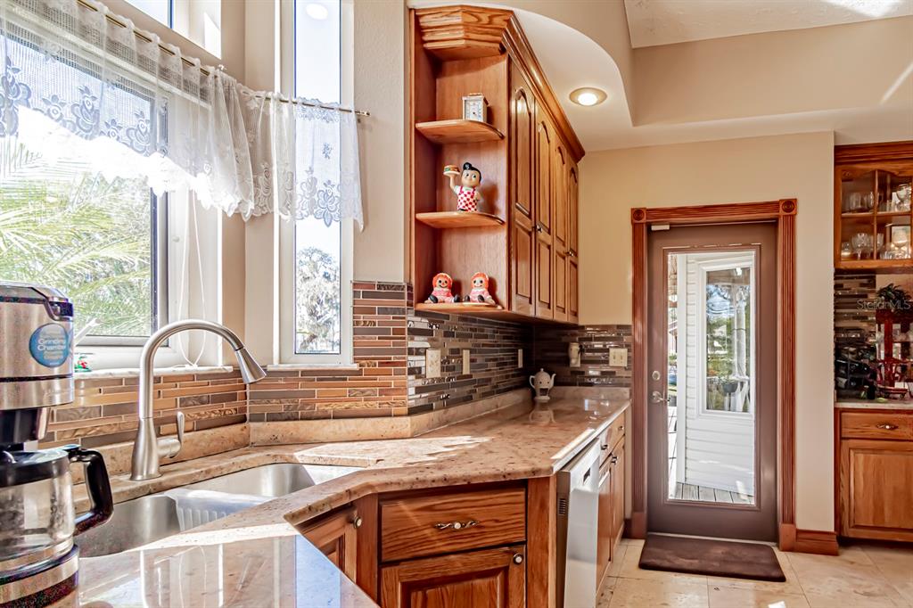9215 Ridge Road New Port Richey, FL 34654 - Photo 30 of 71 a kitchen with stainless steel appliances granite countertop a sink and a stove next to a window