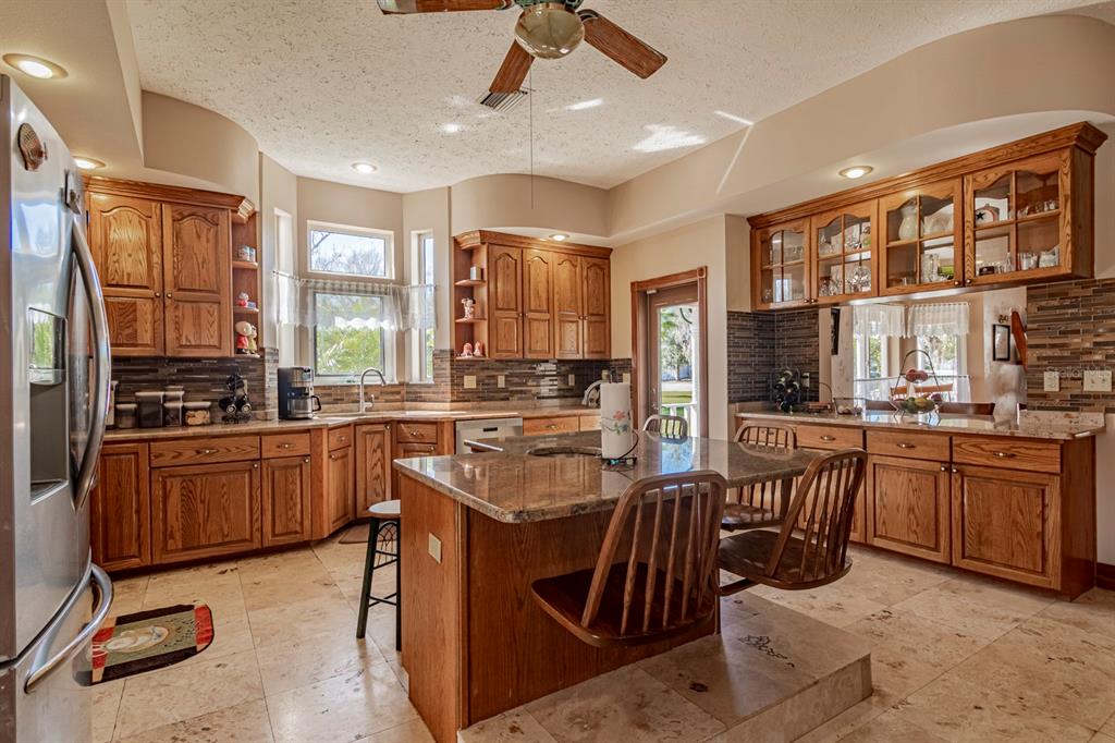9215 Ridge Road New Port Richey, FL 34654 - Photo 32 of 71 a kitchen with stainless steel appliances granite countertop a sink stove and refrigerator