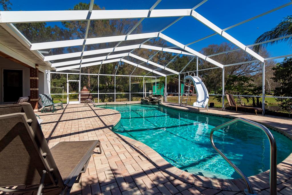 9215 Ridge Road New Port Richey, FL 34654 - Photo 4 of 71 a view of a swimming pool with a patio