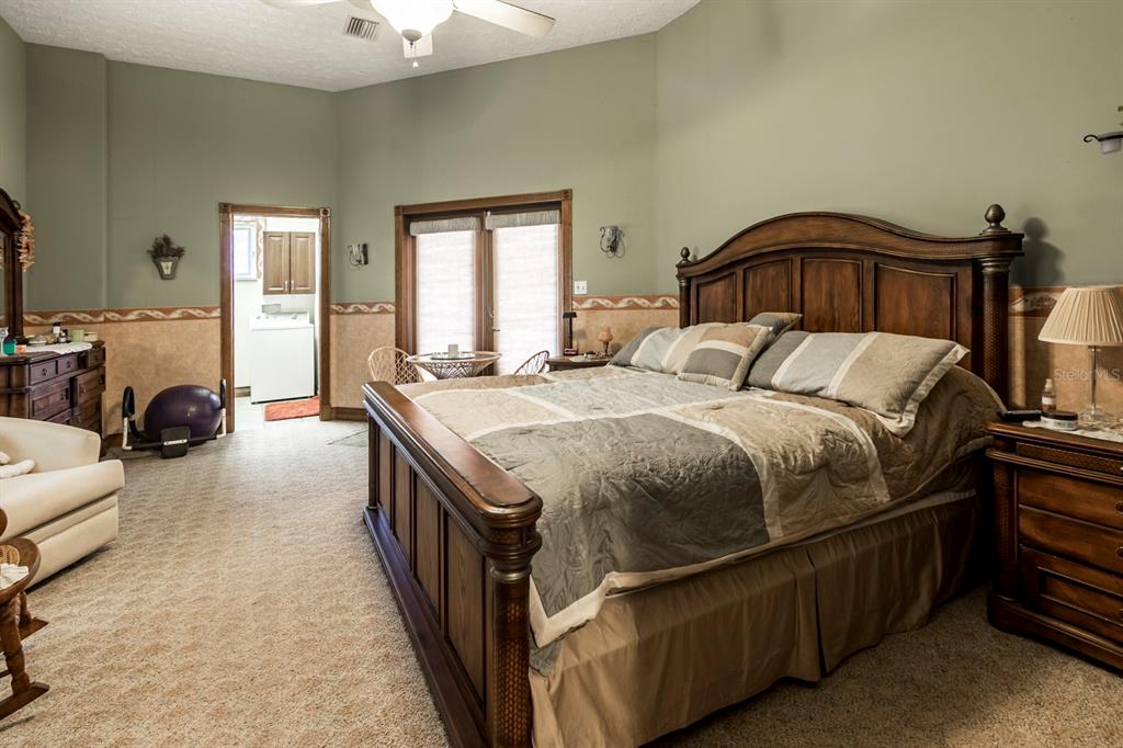 9215 Ridge Road New Port Richey, FL 34654 - Photo 44 of 71 a bedroom with a bed and a chandelier