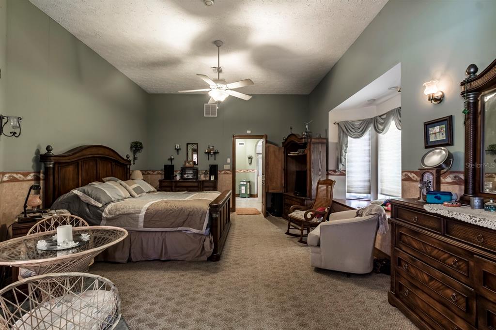 9215 Ridge Road New Port Richey, FL 34654 - Photo 46 of 71 a bedroom with bed or couch and a chandelier