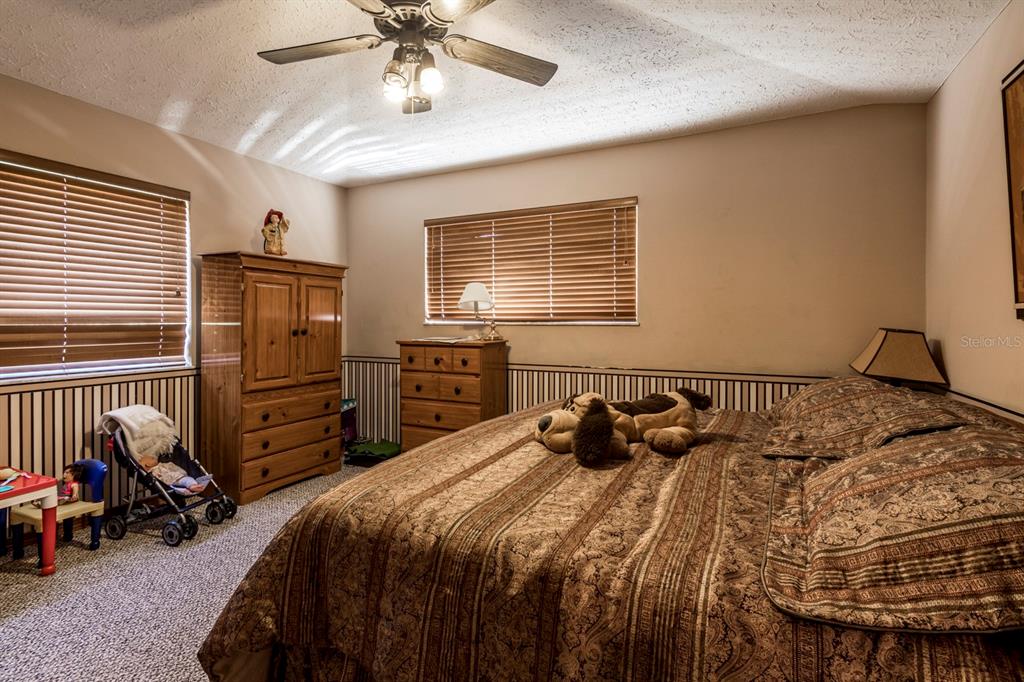 9215 Ridge Road New Port Richey, FL 34654 - Photo 49 of 71 a bedroom with a bed and dresser