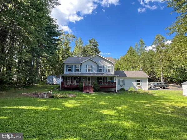 a view of a big house with a big yard and large trees