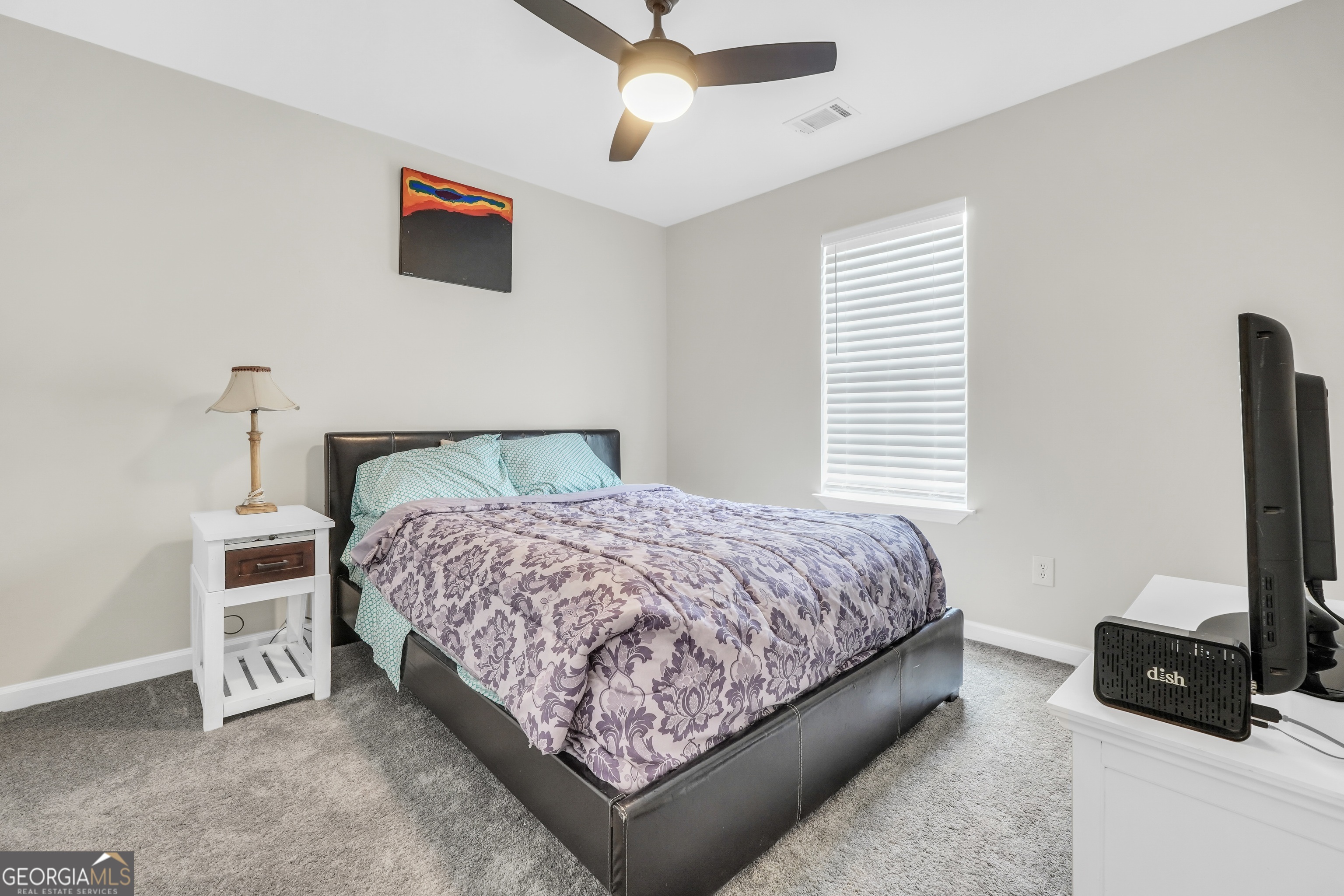 110 Westeria Way Jackson, GA 30233 - Photo 21 of 45 a bedroom with a bed a couch and a flat tv screen