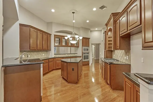 a kitchen with stainless steel appliances granite countertop a stove a sink and a refrigerator