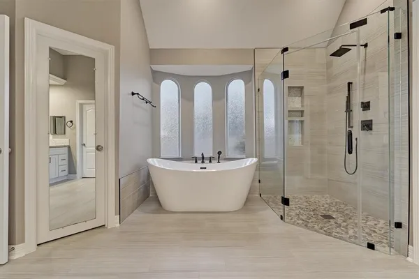 a bathroom with a bathtub shower and toilet