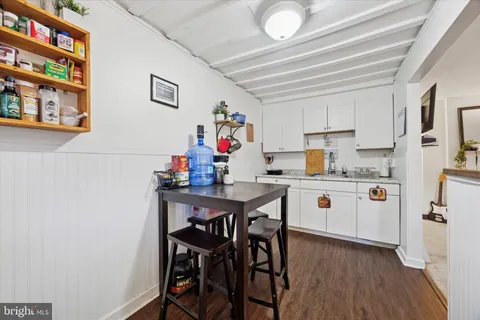 a kitchen with stainless steel appliances a white table chairs and a refrigerator