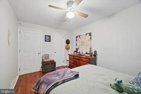 a bedroom with a bed dresser and a chandelier
