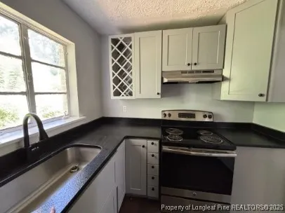 a kitchen with stainless steel appliances granite countertop a sink stove and microwave