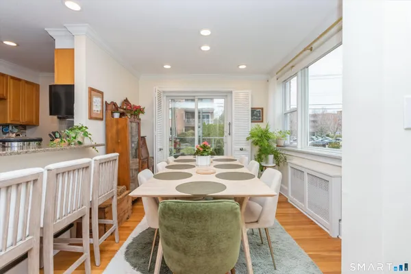 a dining room with furniture and a large window