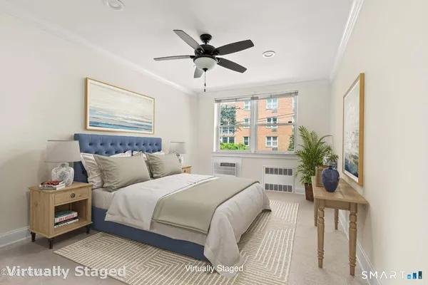 a bedroom with a bed a window and a potted plant
