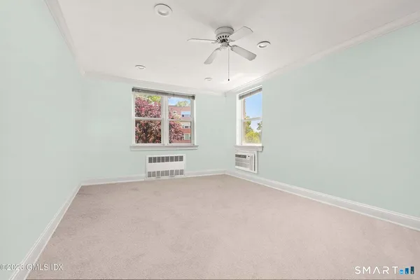 an empty room with windows and fan