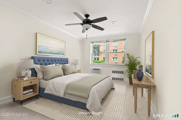 a bedroom with a bed and a potted plant