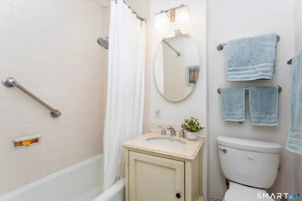 a bathroom with a granite countertop sink mirror vanity and toilet