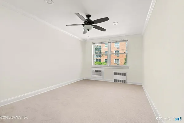 an empty room with windows and ceiling fan