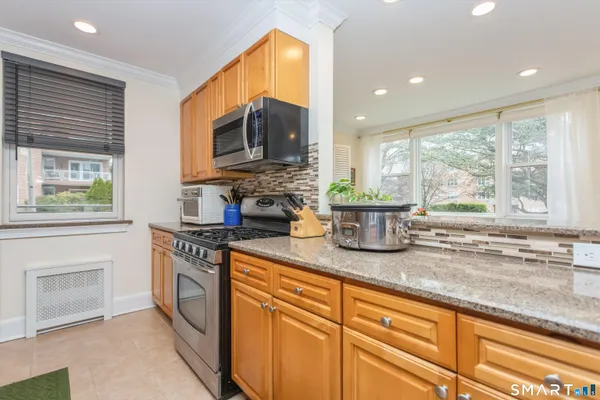 a kitchen with stainless steel appliances granite countertop a stove a sink and a microwave