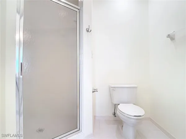 a white toilet sitting next to a shower