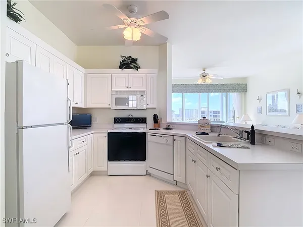 a kitchen with white cabinets and white appliances