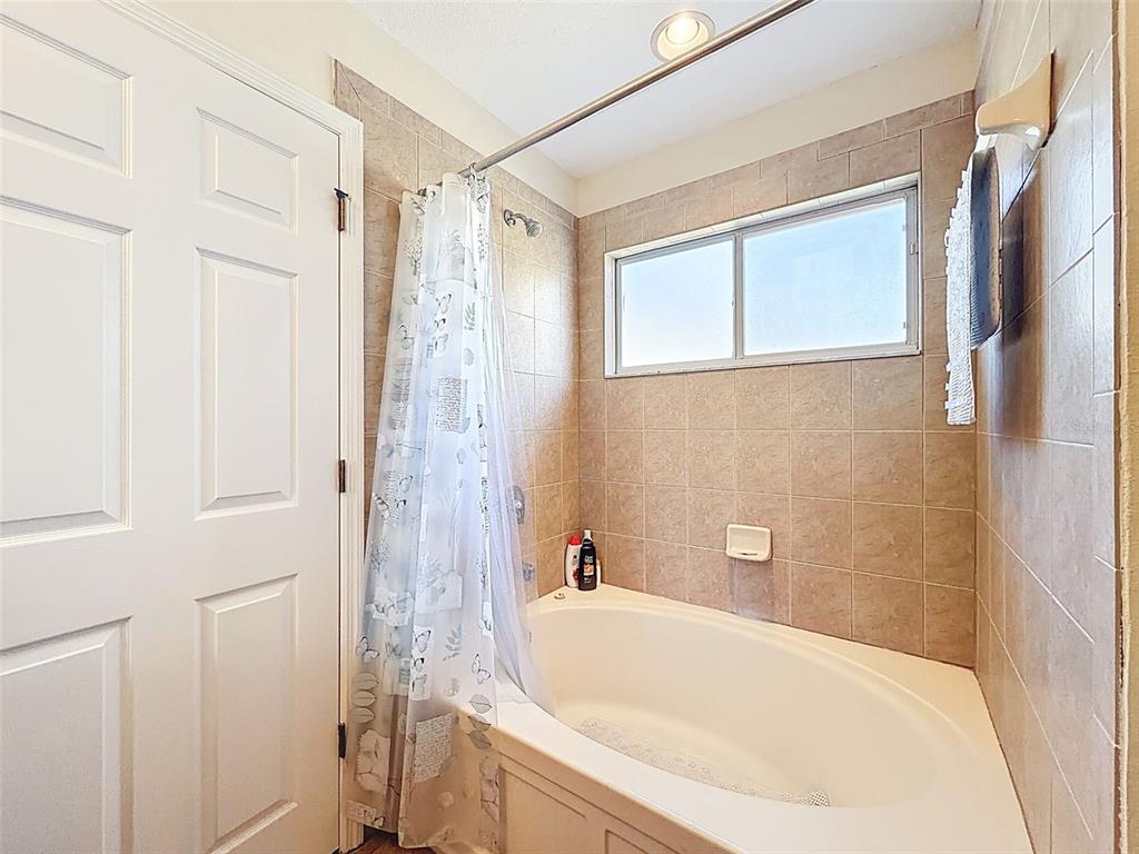 11807 Castine Street New Port Richey, FL 34654 - Photo 14 of 40 a bathroom with a bathtub and a shower