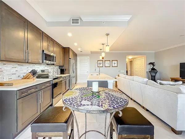 a kitchen with a table chairs microwave and cabinets