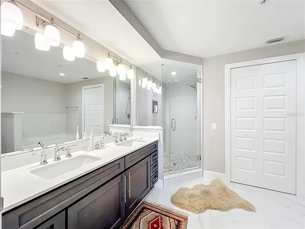 a bathroom with a granite countertop sink mirror and shower