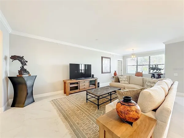 a living room with furniture a flat screen tv and kitchen view