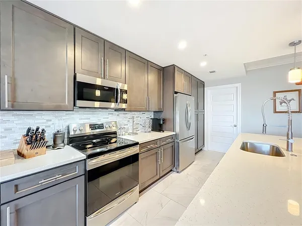 a kitchen with a sink stove top oven and refrigerator