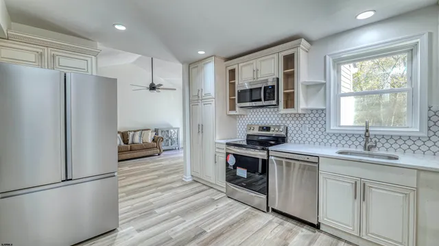 a kitchen with white cabinets and stainless steel appliances
