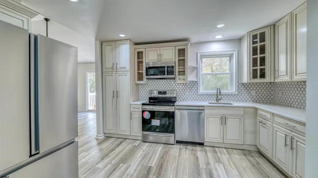 a kitchen with stainless steel appliances granite countertop a stove a sink and a refrigerator