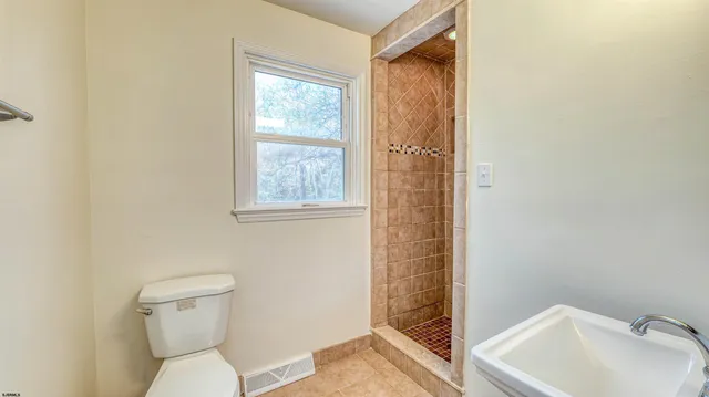 a bathroom with a toilet sink and shower