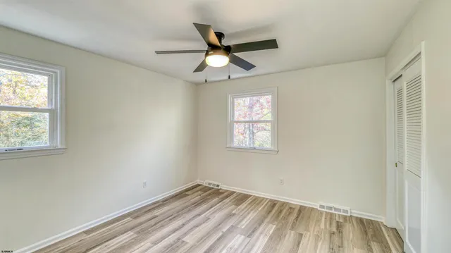 an empty room with a window and a fan
