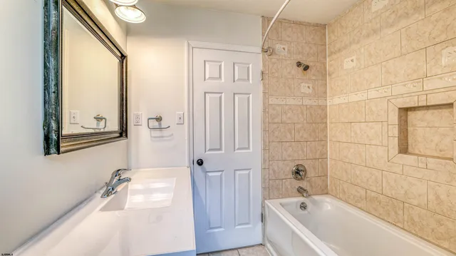 a bathroom with a tub a sink and a large mirror