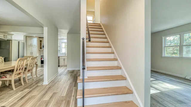 a view of a hallway with wooden floor and dining room