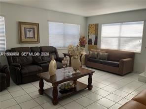 1300 West 53rd Street, Unit 19 Hialeah, FL 33012 - Photo 4 of 7 a living room with furniture and a large window