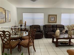 1300 West 53rd Street, Unit 19 Hialeah, FL 33012 - Photo 5 of 7 a living room with furniture and a window