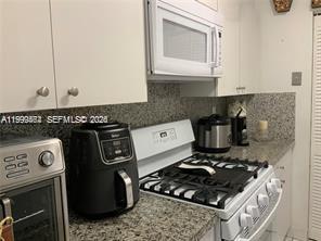 1300 West 53rd Street, Unit 19 Hialeah, FL 33012 - Photo 6 of 7 a kitchen with a stove and a microwave