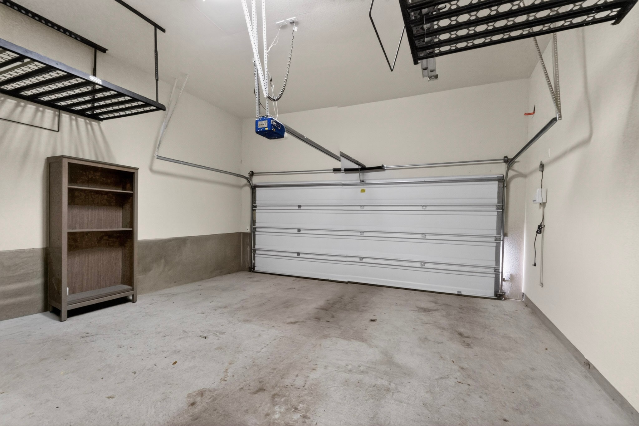 178 Limestone Trail Austin, TX 78737 - Photo 37 of 40 Spacious garage featuring a concrete floor, white walls, and a large overhead door
